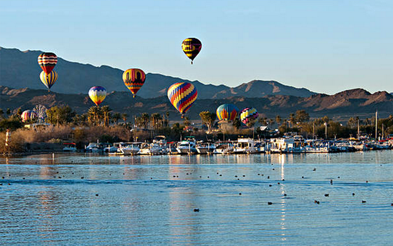 several hot air balloons flying over Lake Havasu.