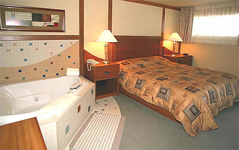 A view of the bedroom and whirlpool tub in a First Cabin Club suite
