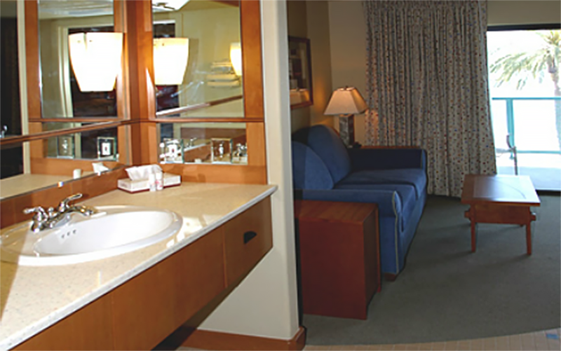 A view of the vanity, living area, and balcony of a First Cabin Club suite